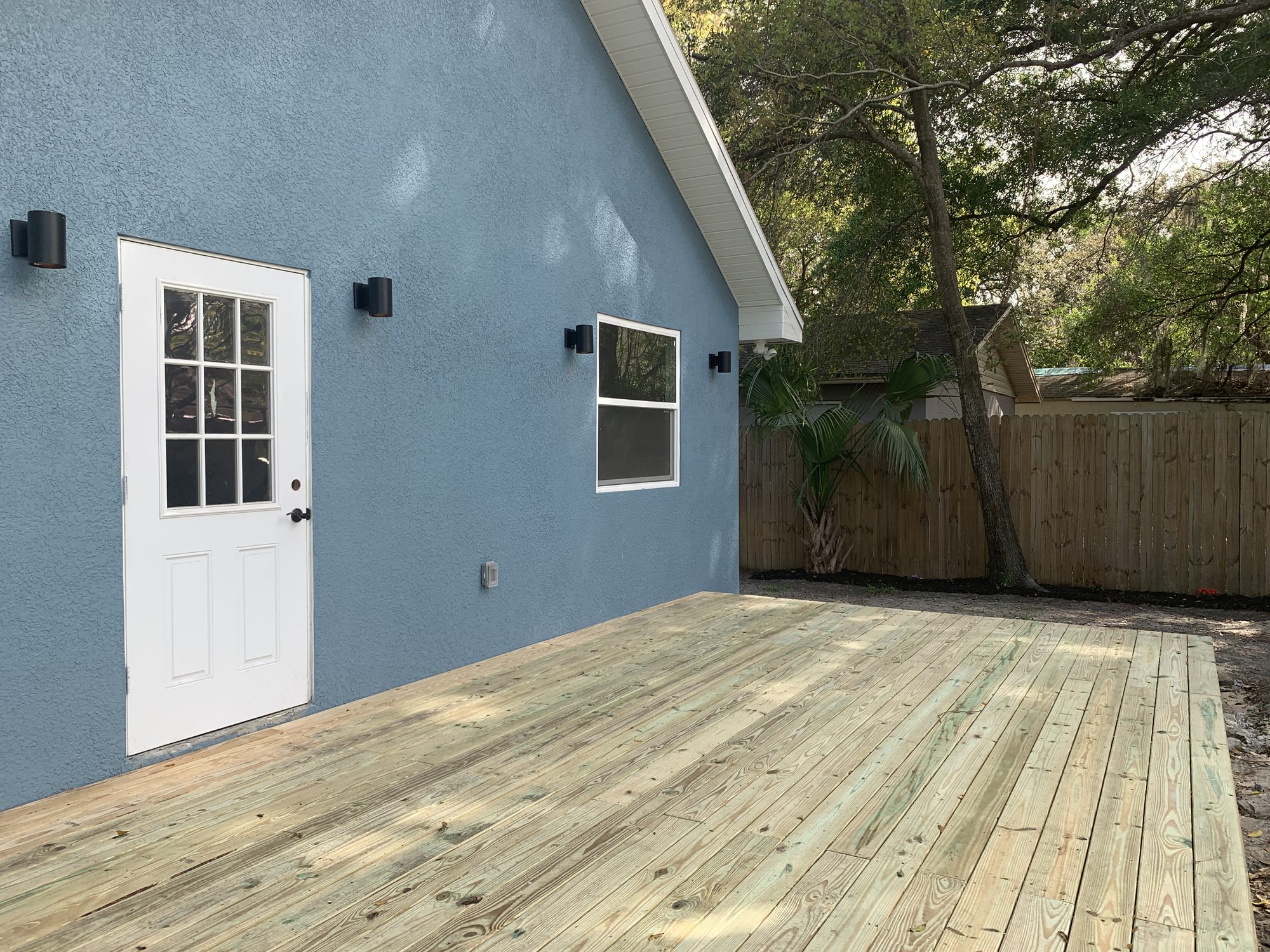New pressure-treated deck on blue stucco home — Blue Diamond Building, Northeast Florida